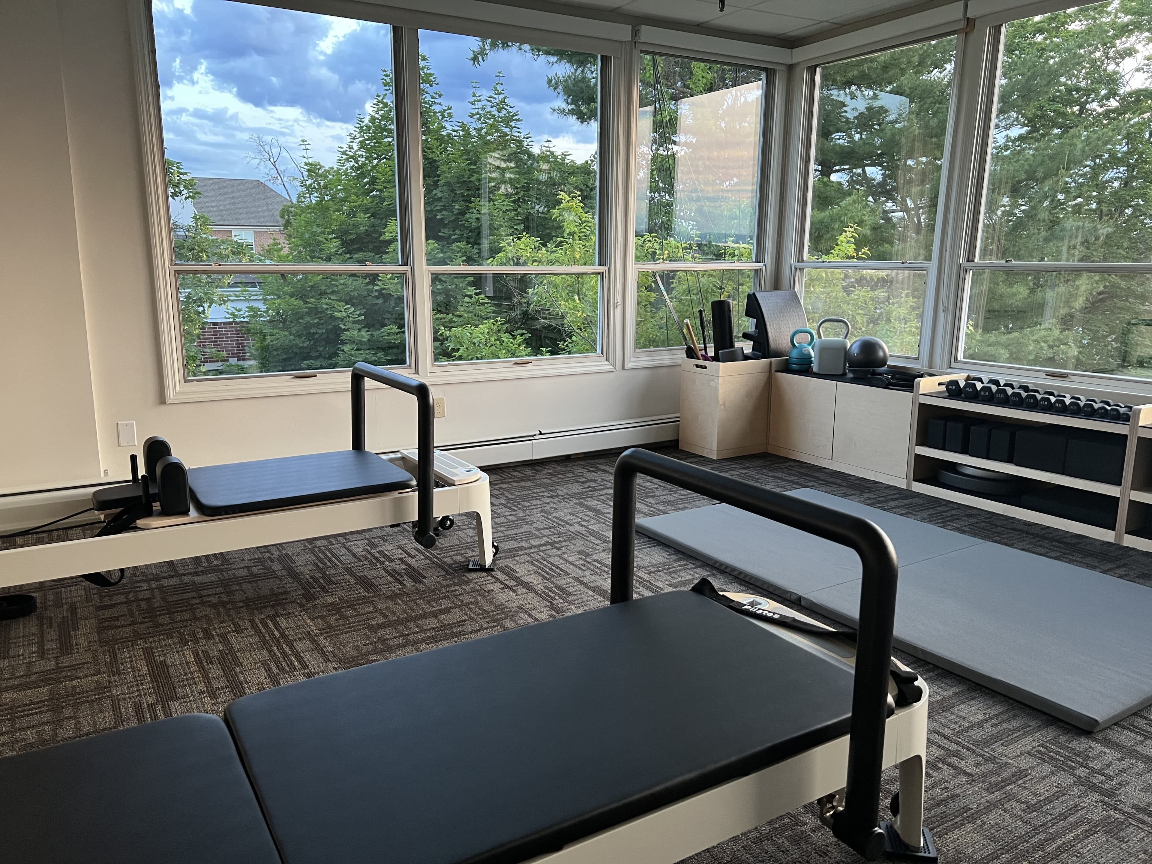 Pilates reformers in a bright corner room
