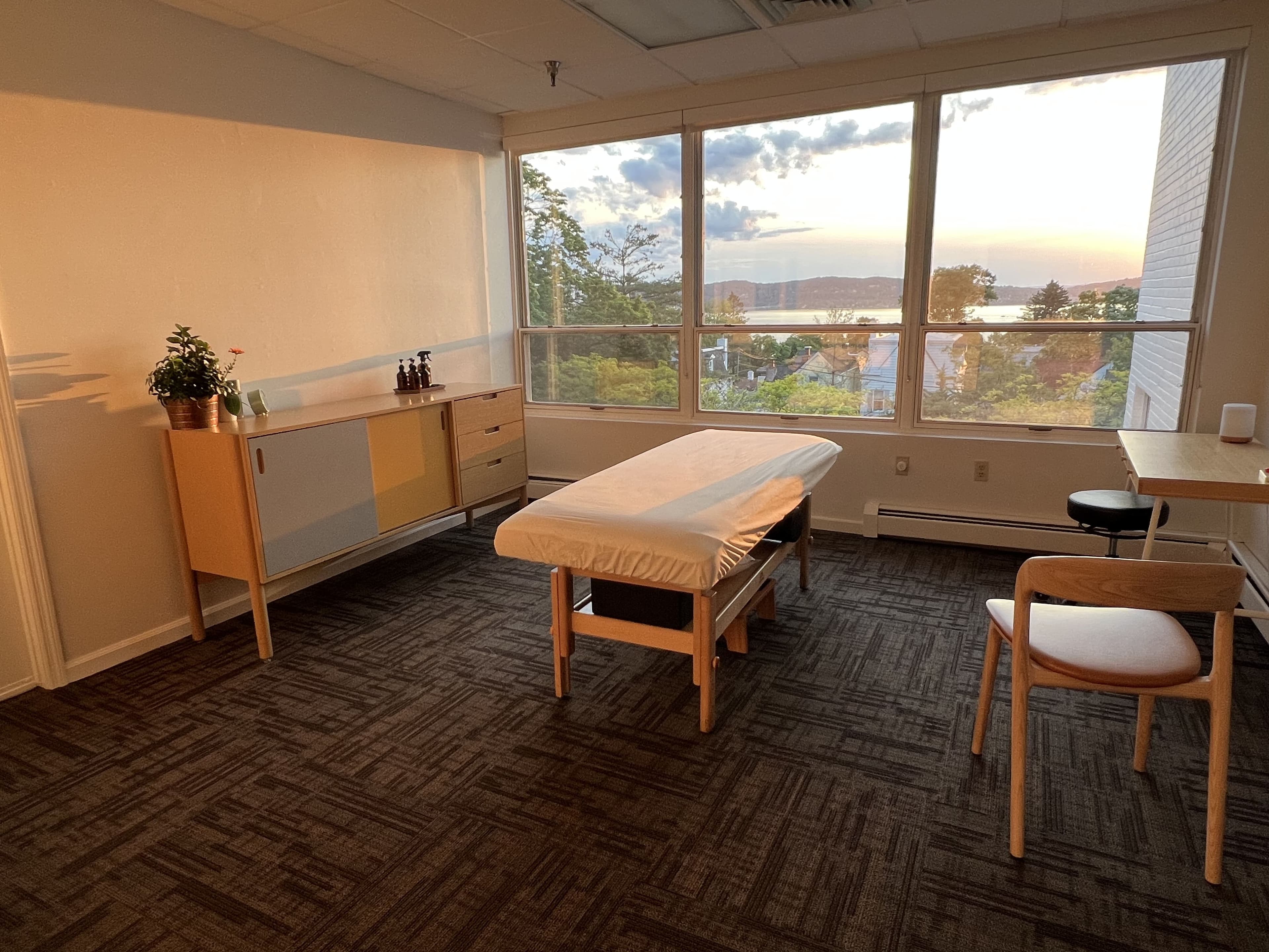 Treatment room with a padded table and river views