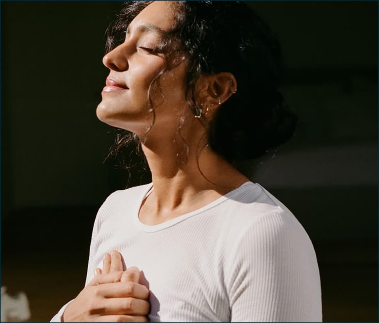 Woman with eyes closed, face lifted to the sun